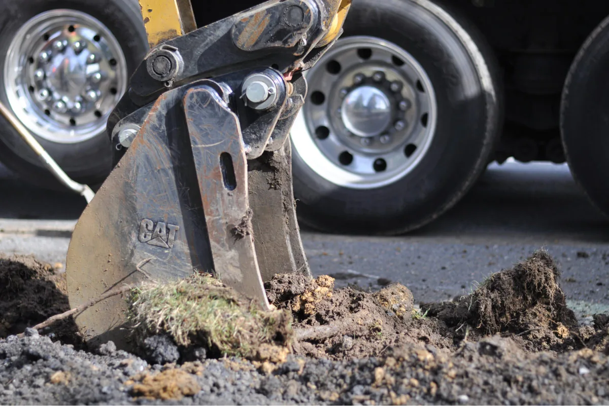 excavator grabbing a claw of soil